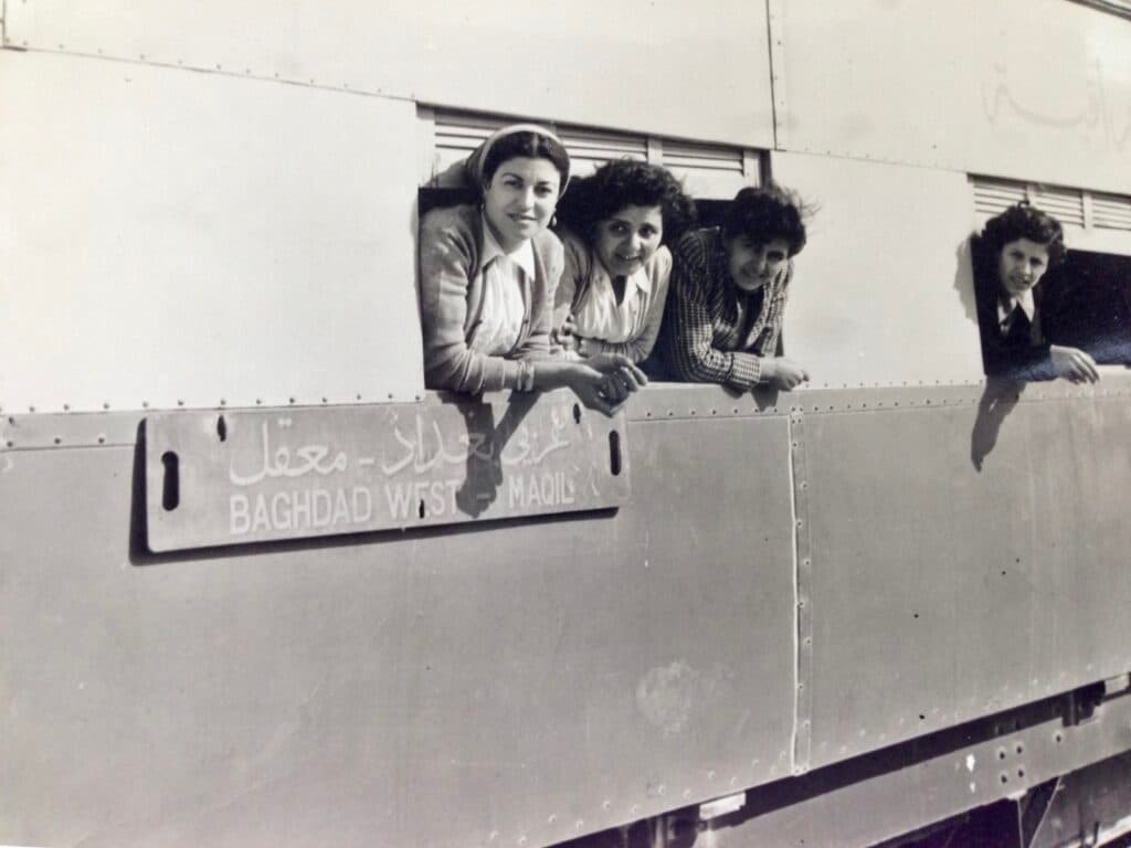 People leaning from a train window in a historical photograph