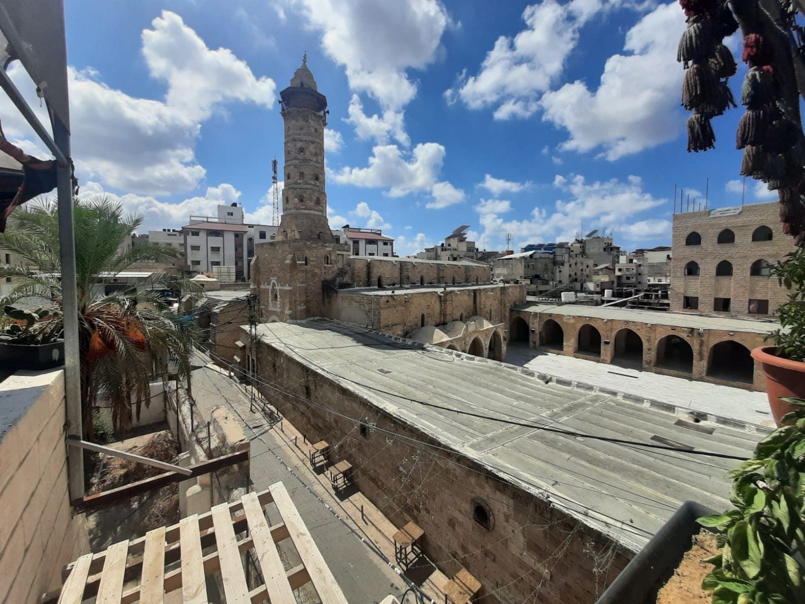 Rooftops, a mosque, and historic stone buildings beneath a blue sky